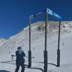 Mariah standing in front of a trail sign showing the name of the train is Humbug at Arapahoe Basin