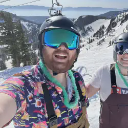 Alex and Mariah skiing in June with a view of Lake Tahoe in the background